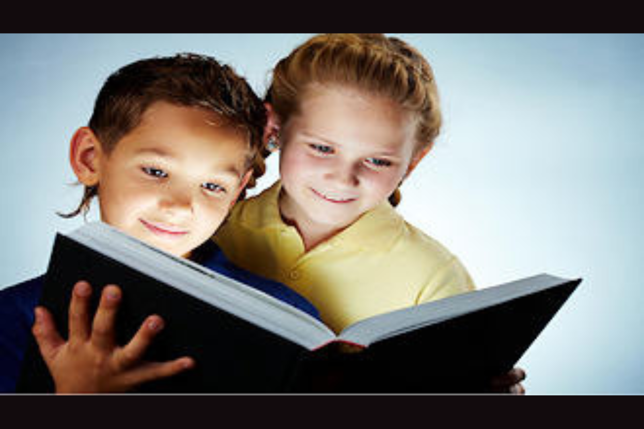 2 children looking at an open book