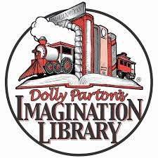 A row of books with train bookends at either end of the row. All sit on top of an open book. Dolly Parton's Imagination Library